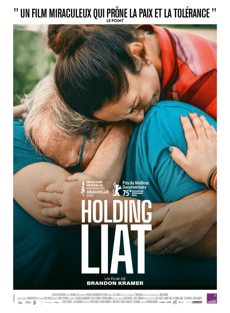 Affiche du film 'Holding Liat', présentant deux personnes s'enlaçant chaleureusement avec un fond coloré. Le texte inclut une citation élogieuse et des informations sur la sélection du film dans des festivals.